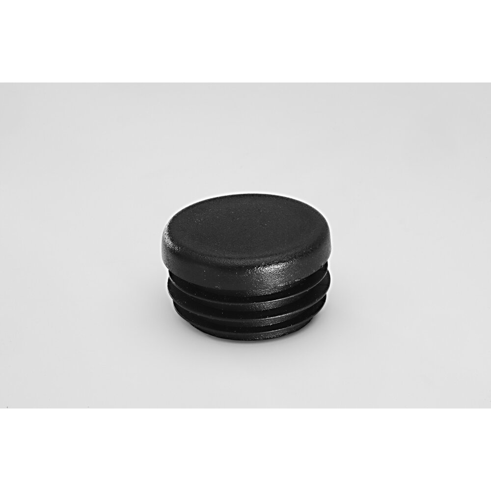 Black plastic pipe end cap with ridges on a light gray background
