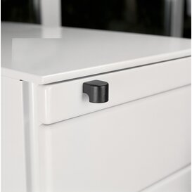 Close-up of a white drawer corner with a black, rounded corner handle attached.